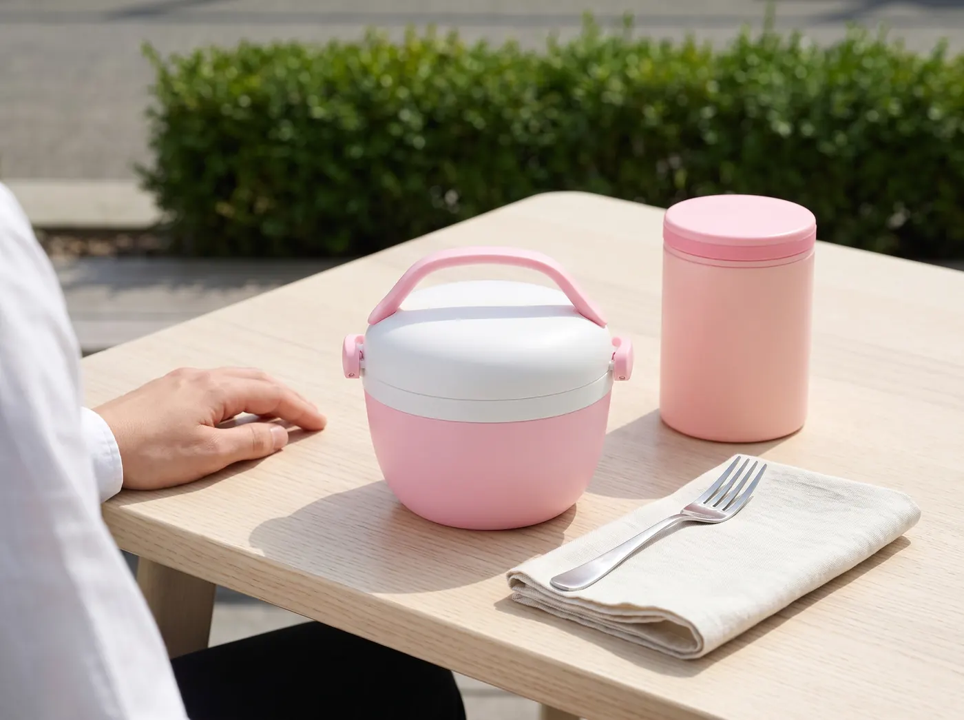 Carmanyola tèrmica rosa i termo per a aliments Runbott a la taula d'una terrassa